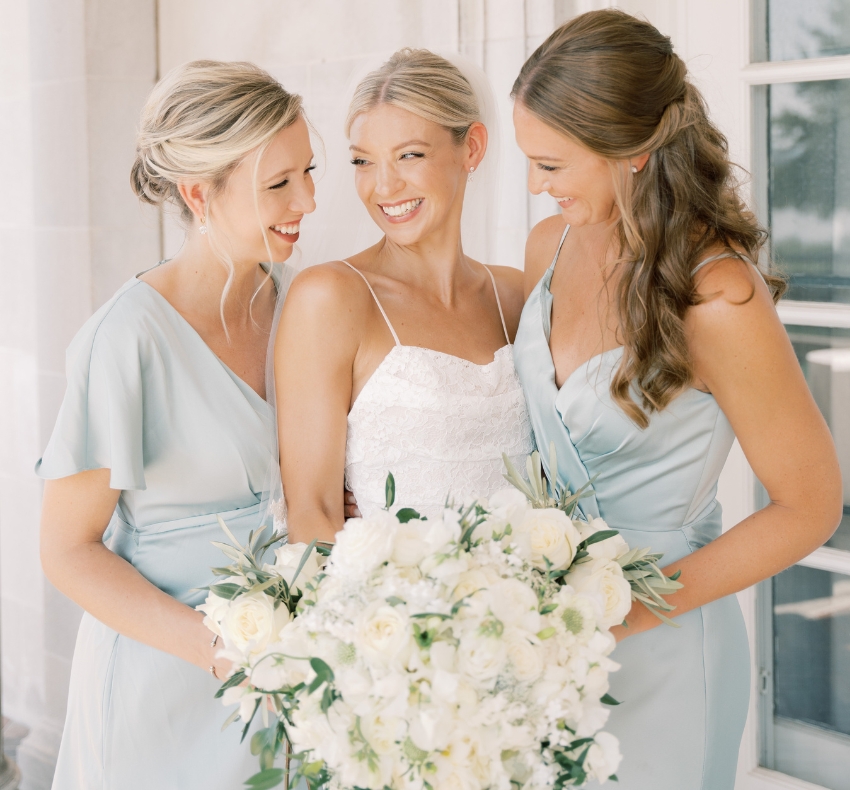 Bride in white with her two bridesmaids in blue